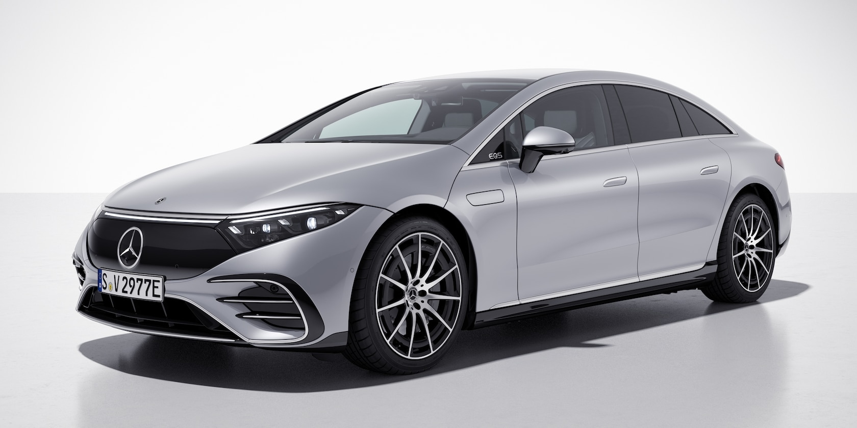 Mercedes-Benz EQS 580 front exterior view in silver showcasing aerodynamic design and LED headlights