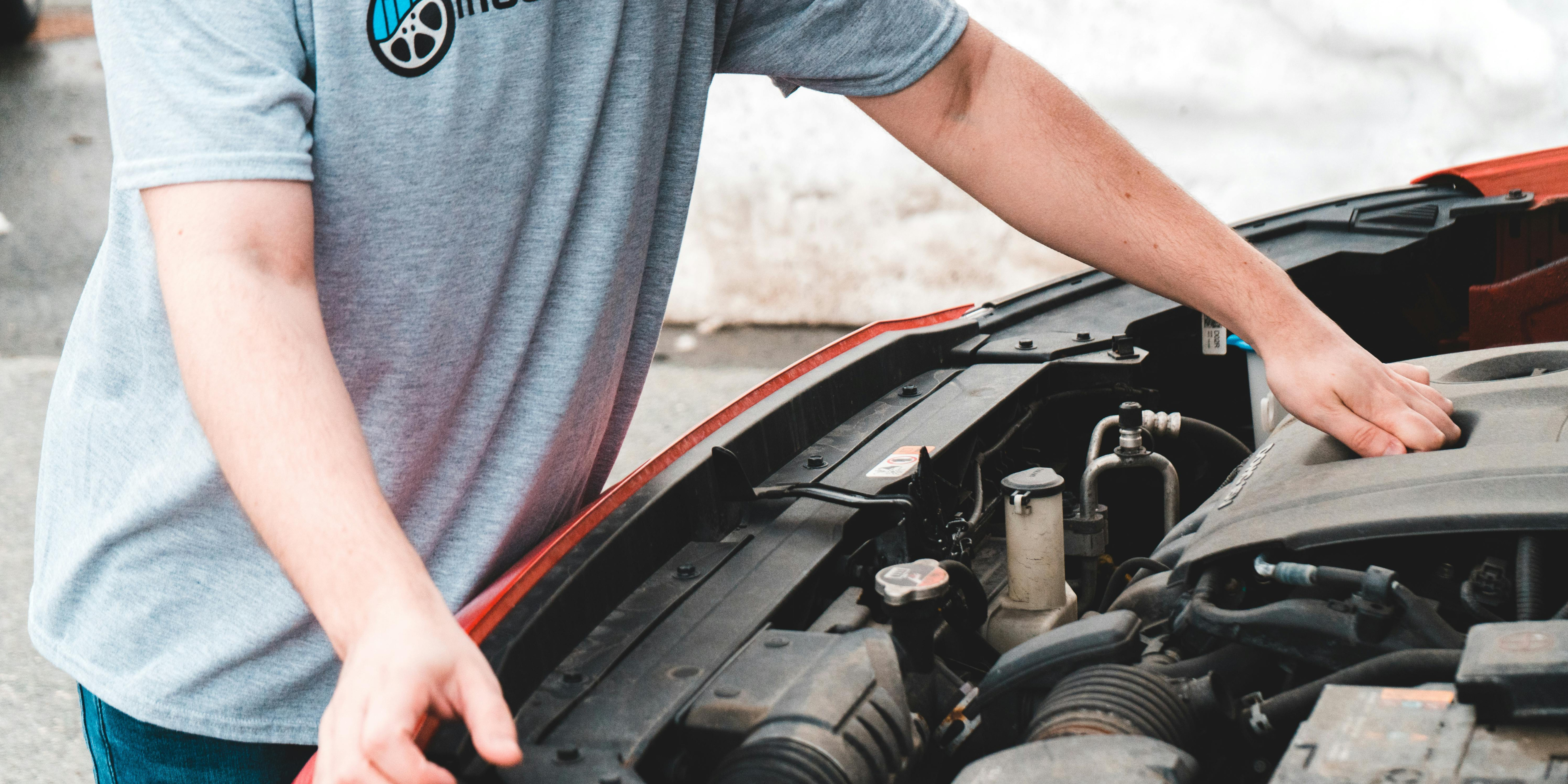 Car buyer inspecting a vehicle engine bay during a pre-purchase check to avoid issues when buying a used car.