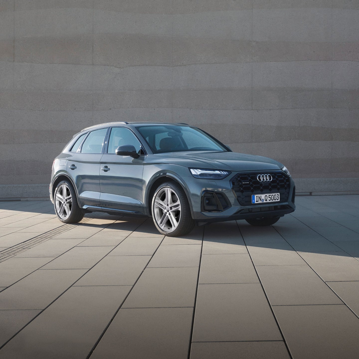 sleek grey Audi Q3 SUV parked outdoors featuring sharp LED headlights, a large black grille, and modern alloy wheels.