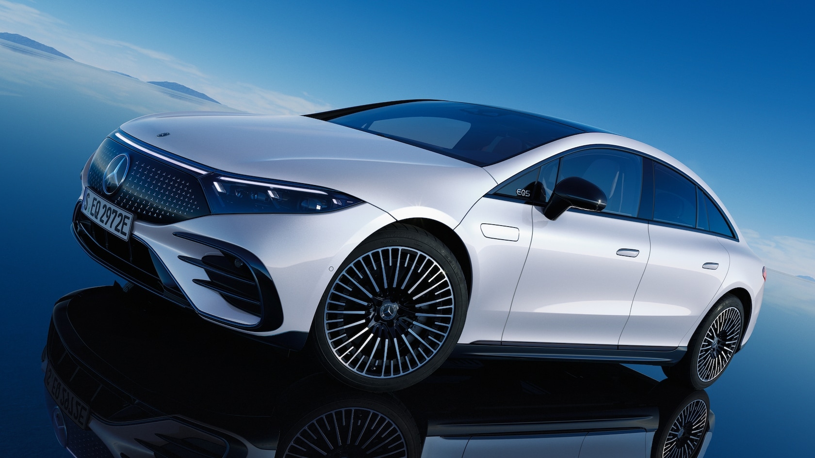 Mercedes-Benz EQS 580 luxury electric sedan with panoramic roof displayed against a blue sky backdrop.