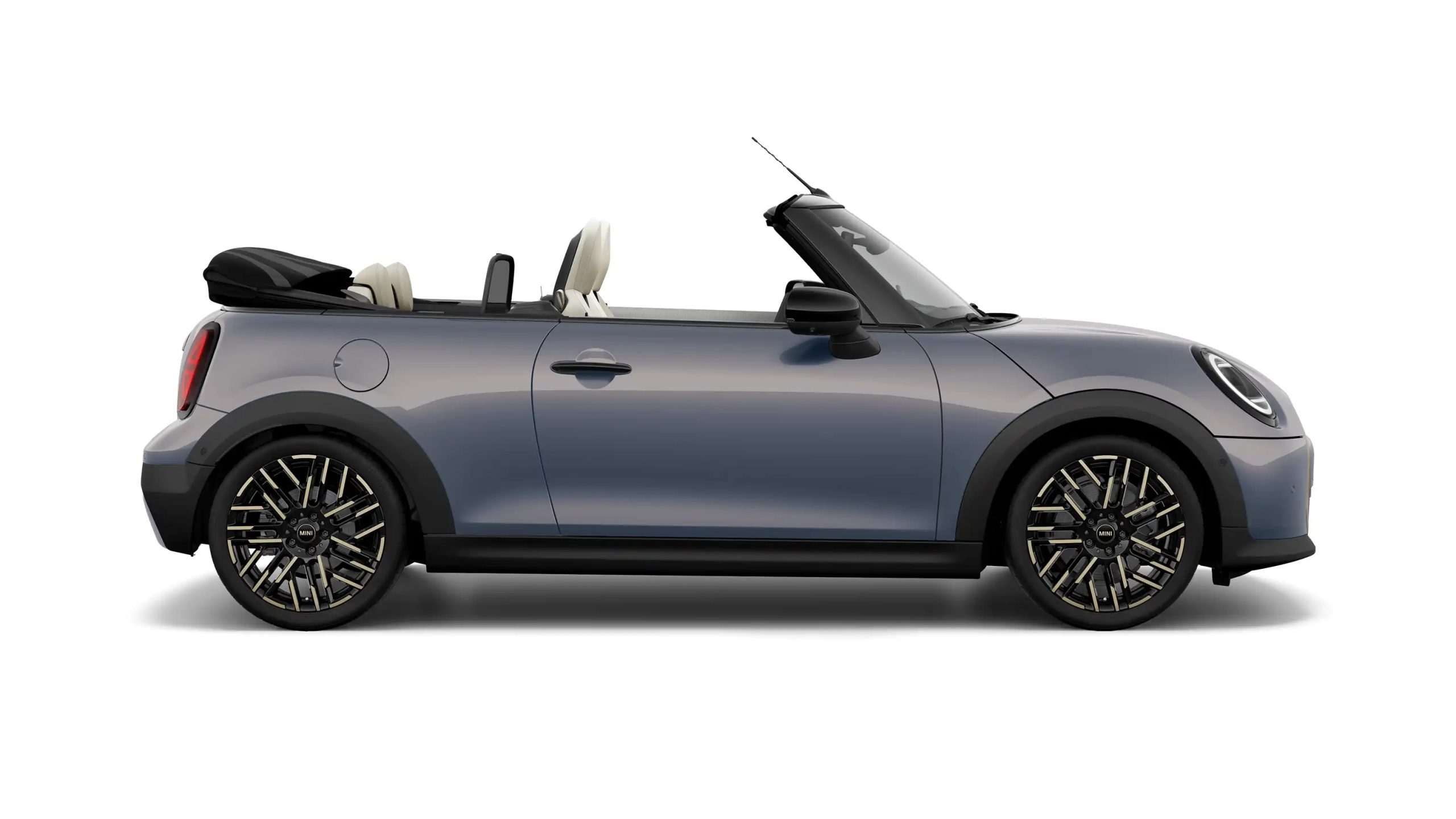 2025 MINI Convertible in grey displayed on a white studio background with the top down, highlighting its sleek silhouette and premium alloy wheels.
