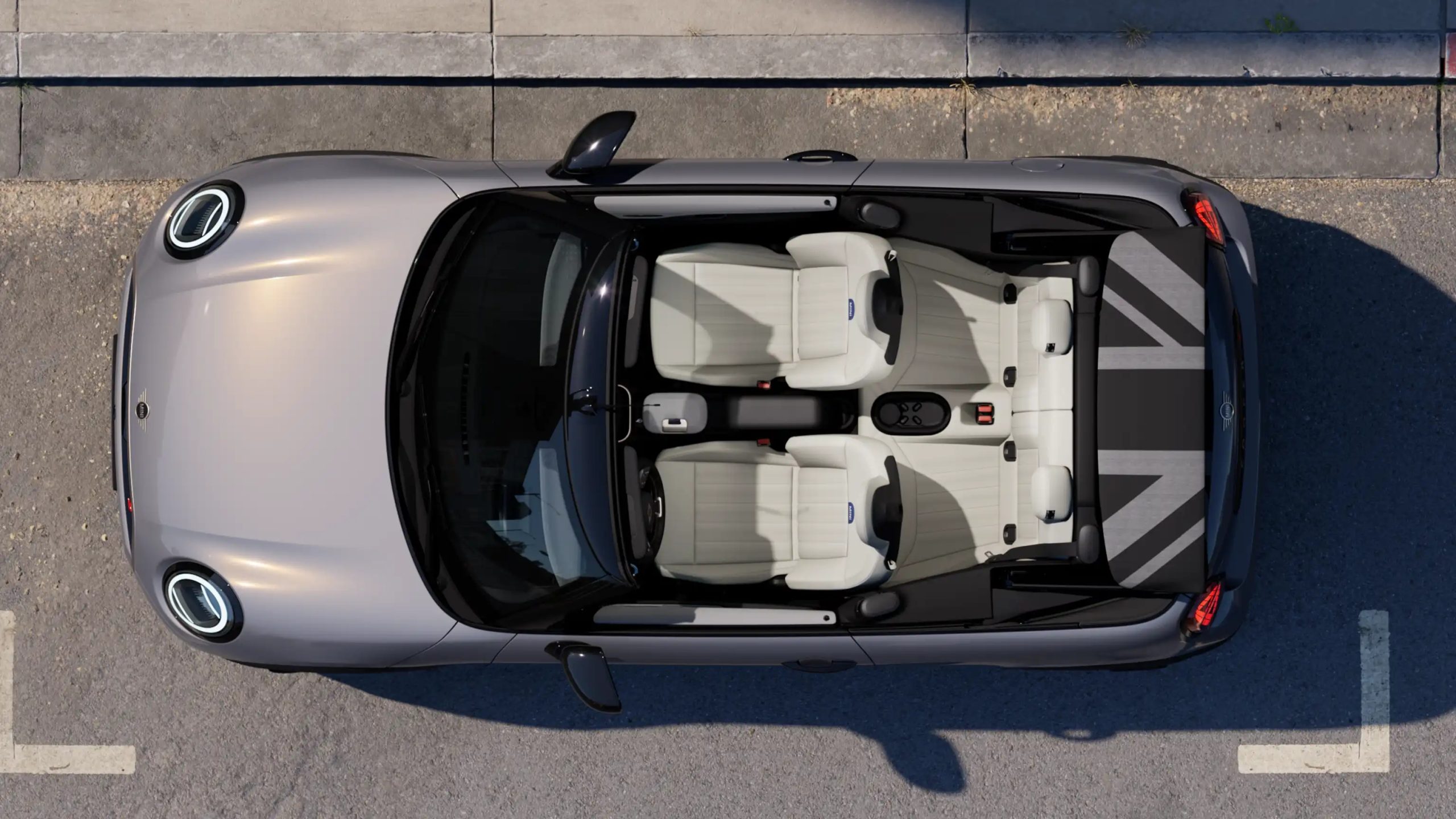 Top-down view of the 2025 MINI Convertible featuring four-seat layout, cream leather interior, and Union Jack design on the soft-top cover.