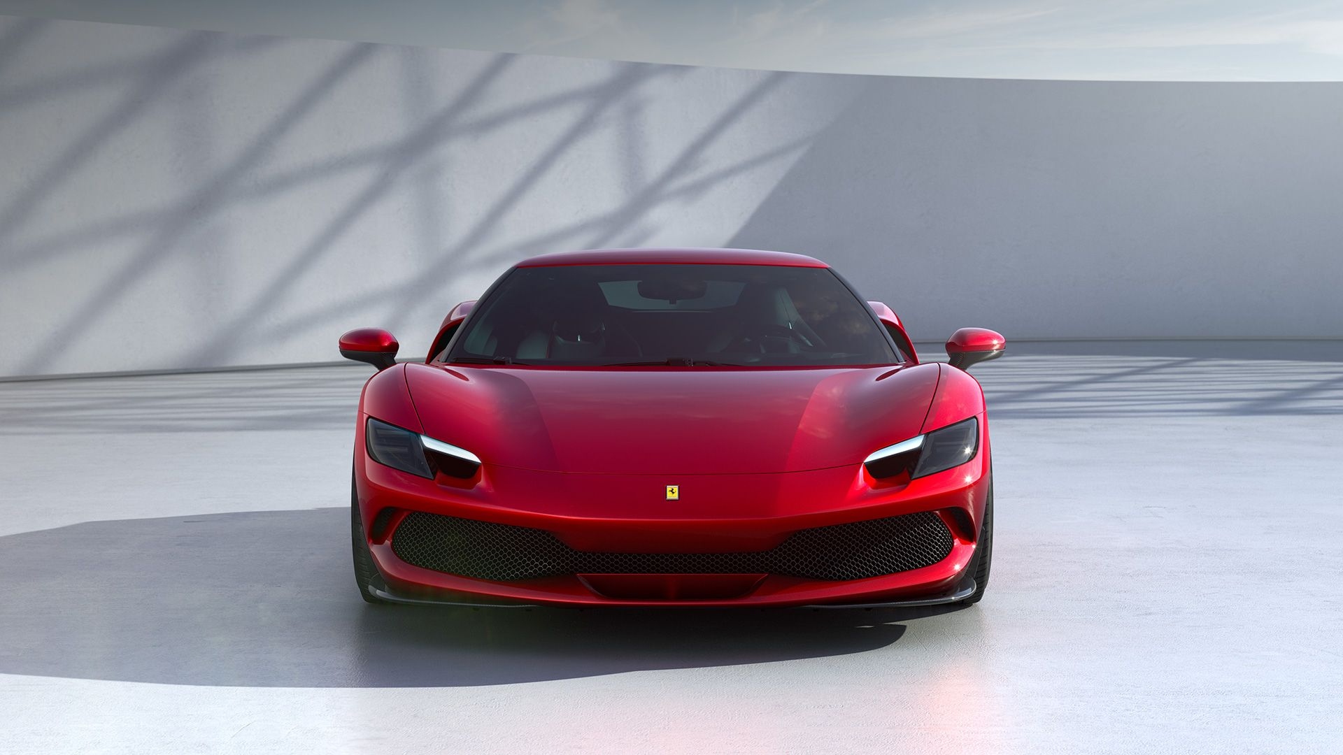 Red Ferrari sports car front profile in minimal studio backdrop