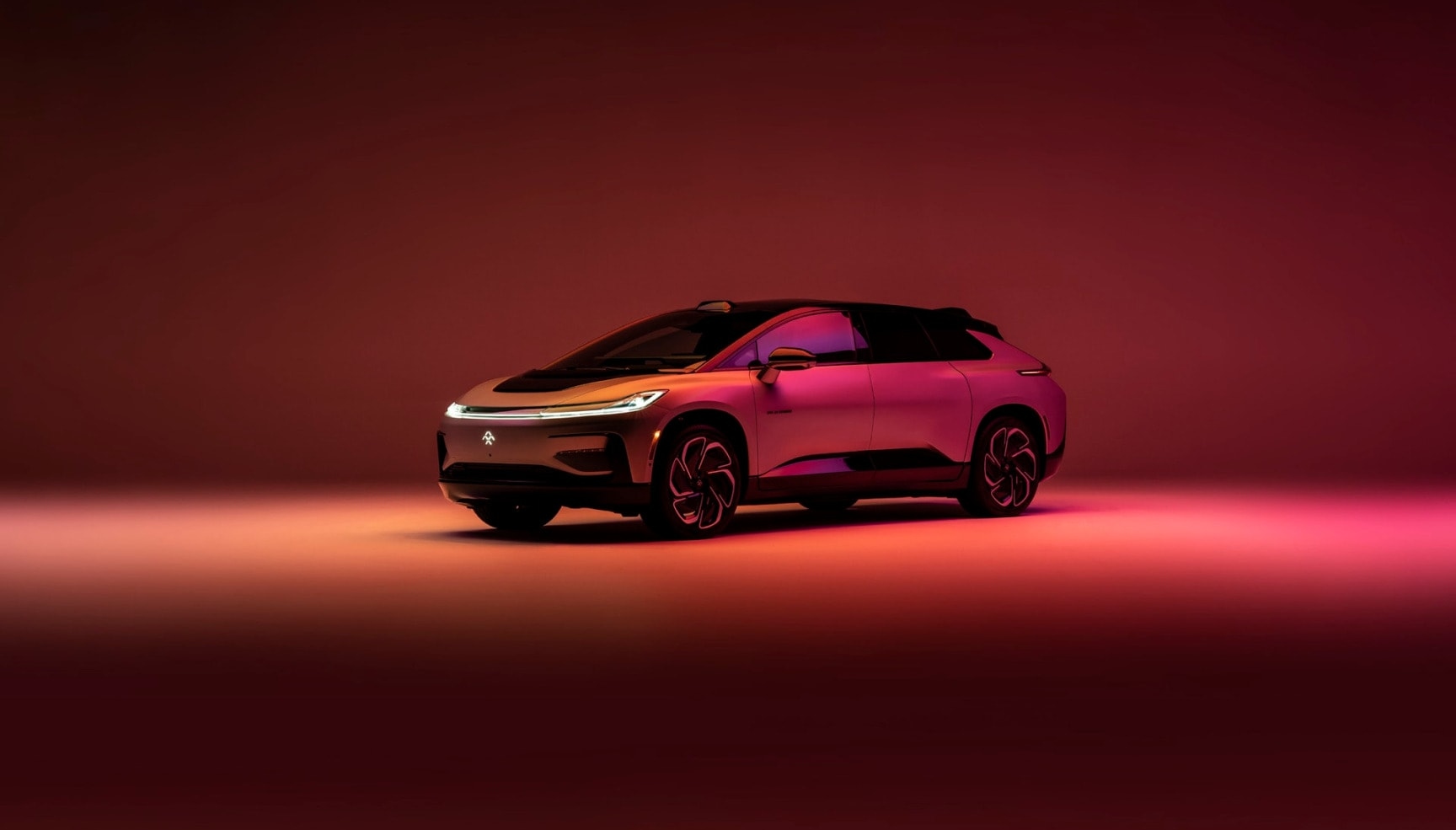 Faraday Future FF 91 electric SUV showcased under dramatic red and pink studio lighting