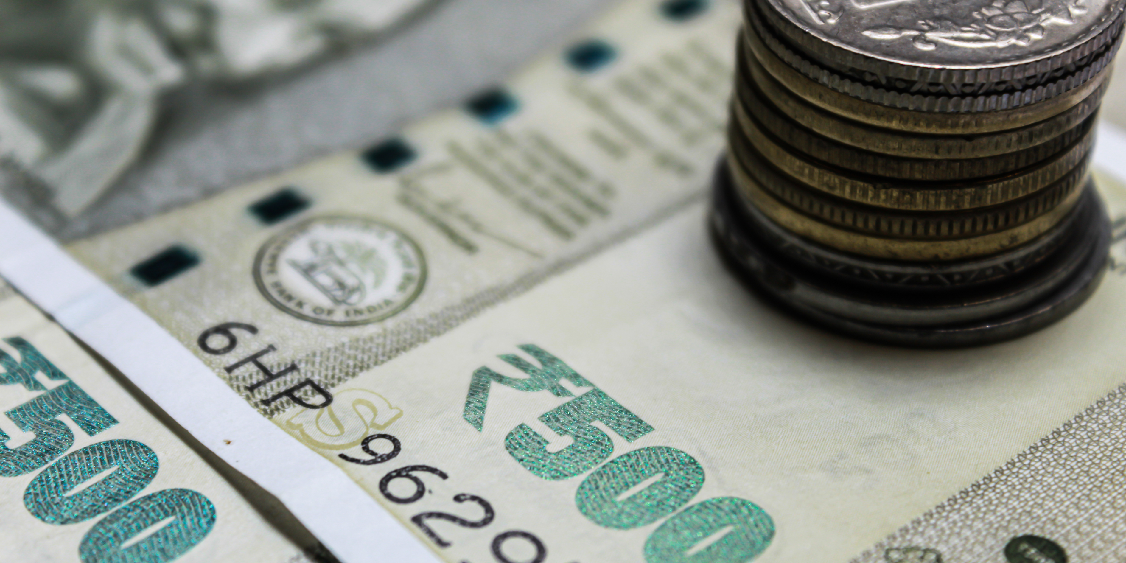 Stack of Indian coins placed on a ₹500 currency note.
