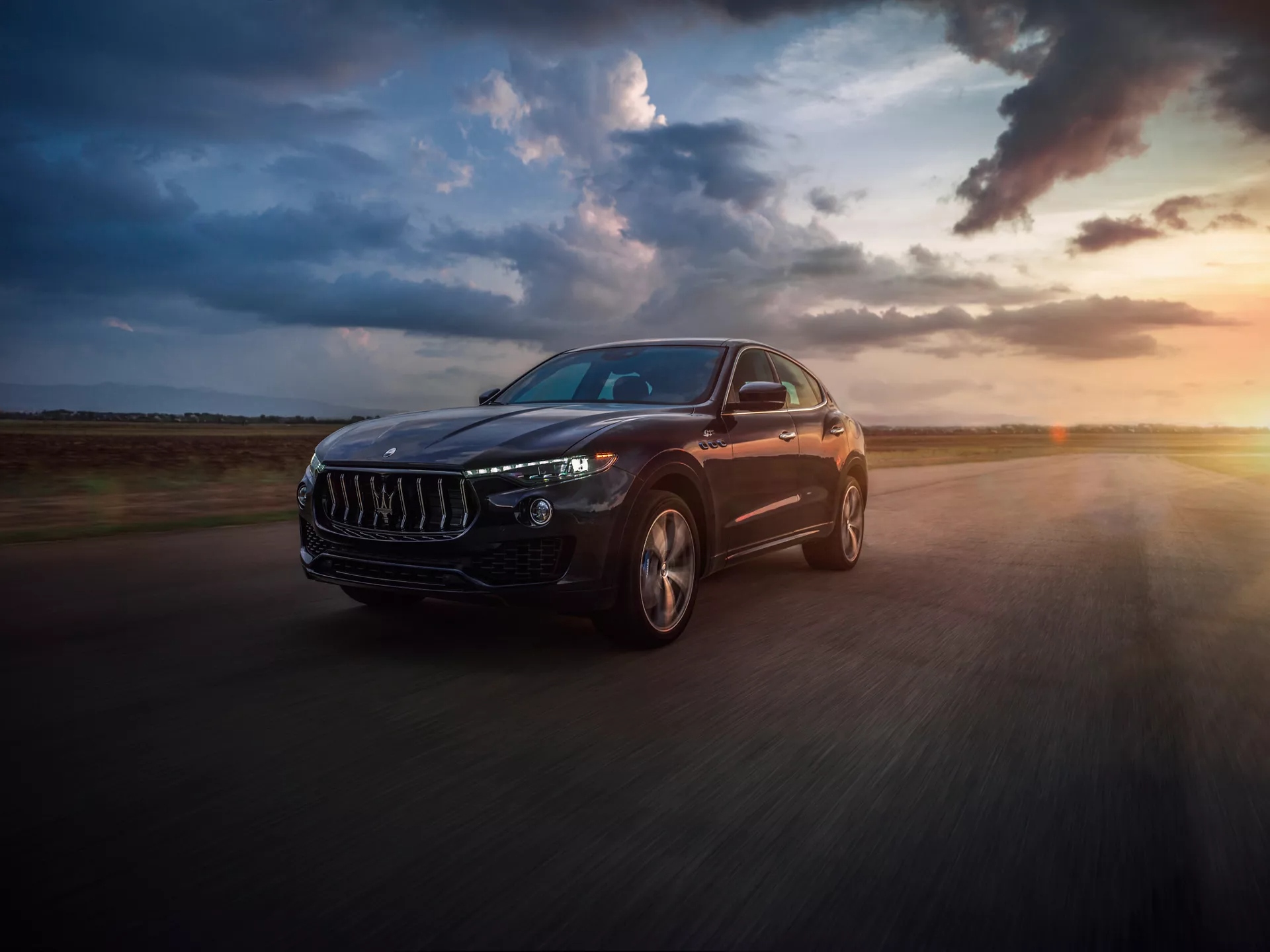 Maserati Levante black luxury SUV driving at sunset